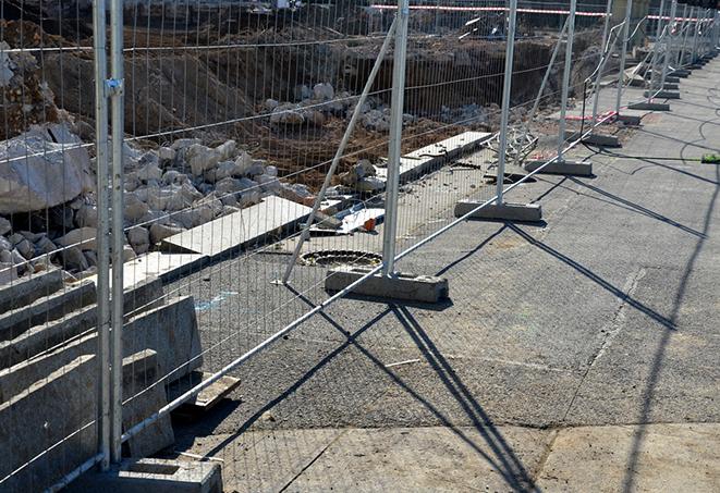 a group of temporary fence panels being used to create a privacy barrier on a construction site